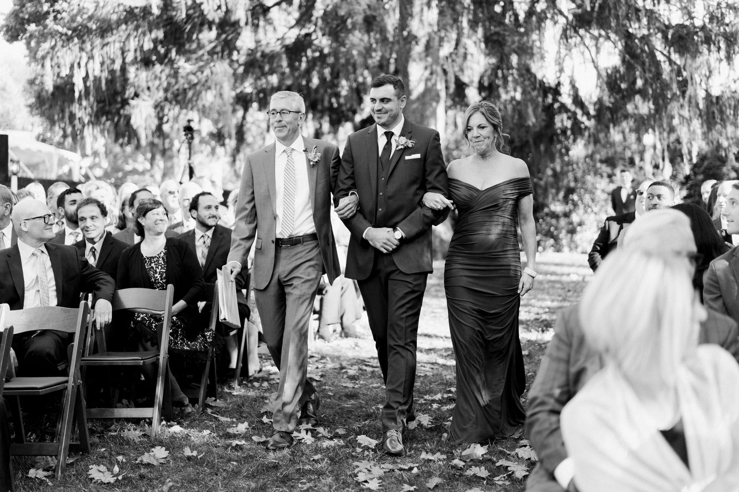 Wedding ceremony processional captured in black and white under Spanish moss trees.