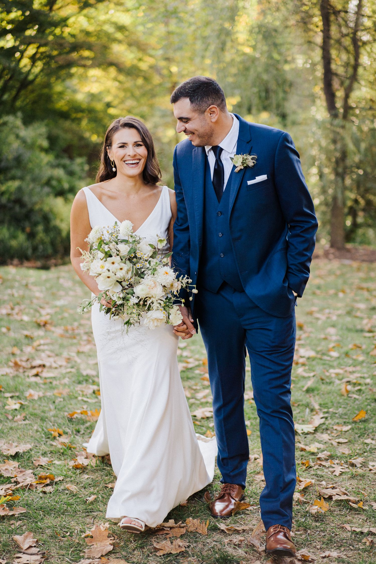 Intimate wedding portrait of couple sharing joyful laughter in garden setting.