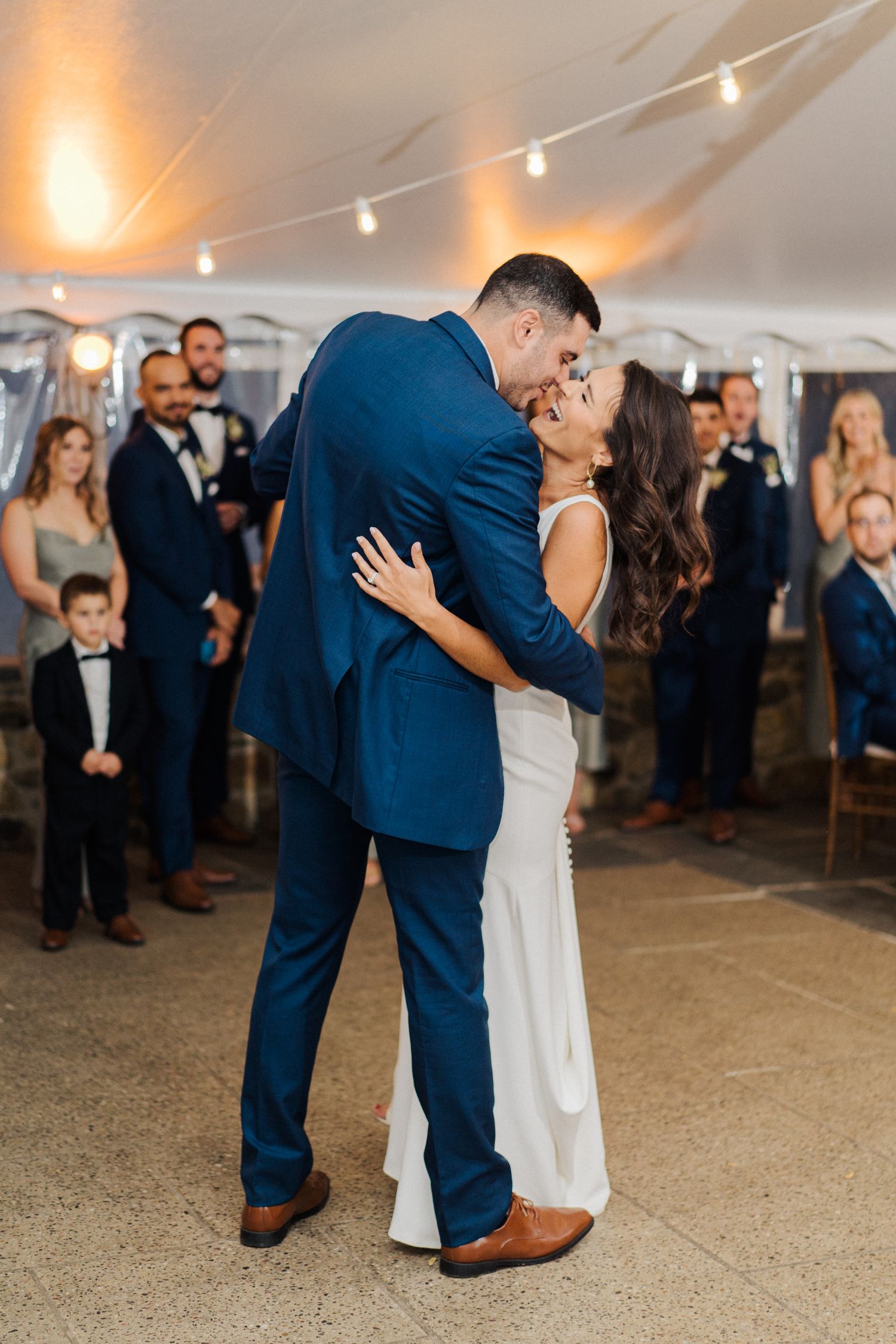Intimate dance moment captured under warm tent lighting at reception.