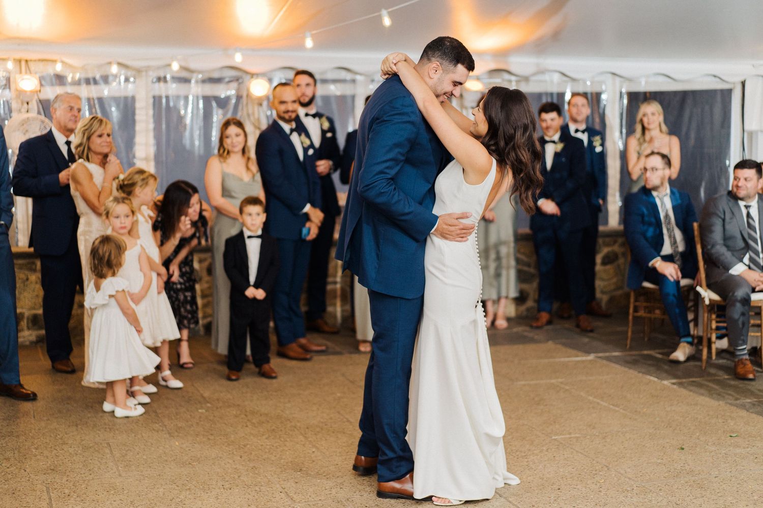 First dance moment in tent reception with guests watching.