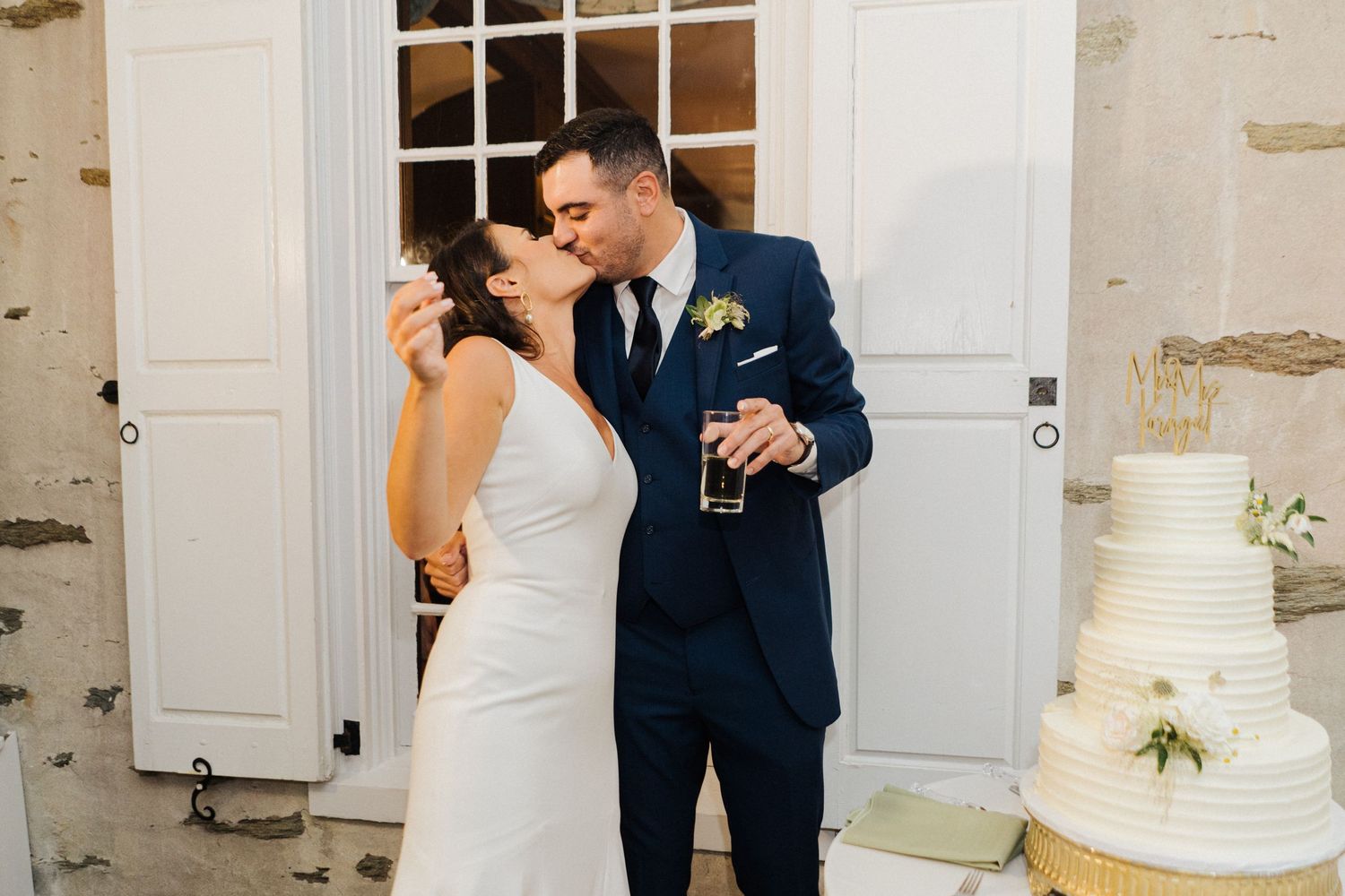 A couple shares a joyful moment while enjoying cake at their wedding reception.