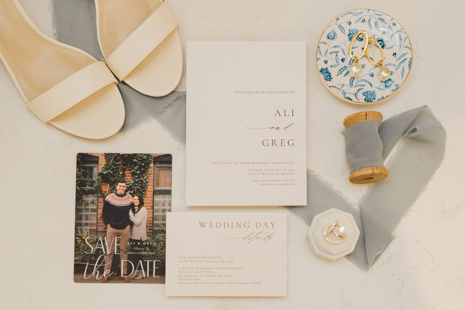 Wedding details flat lay with invitation, shoes, save the date card and silk ribbons.