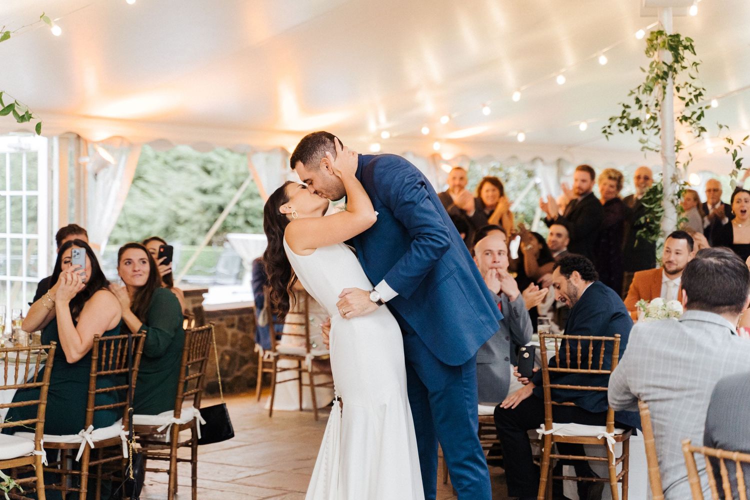 A romantic first dance moment in a tent reception with string lights overhead.