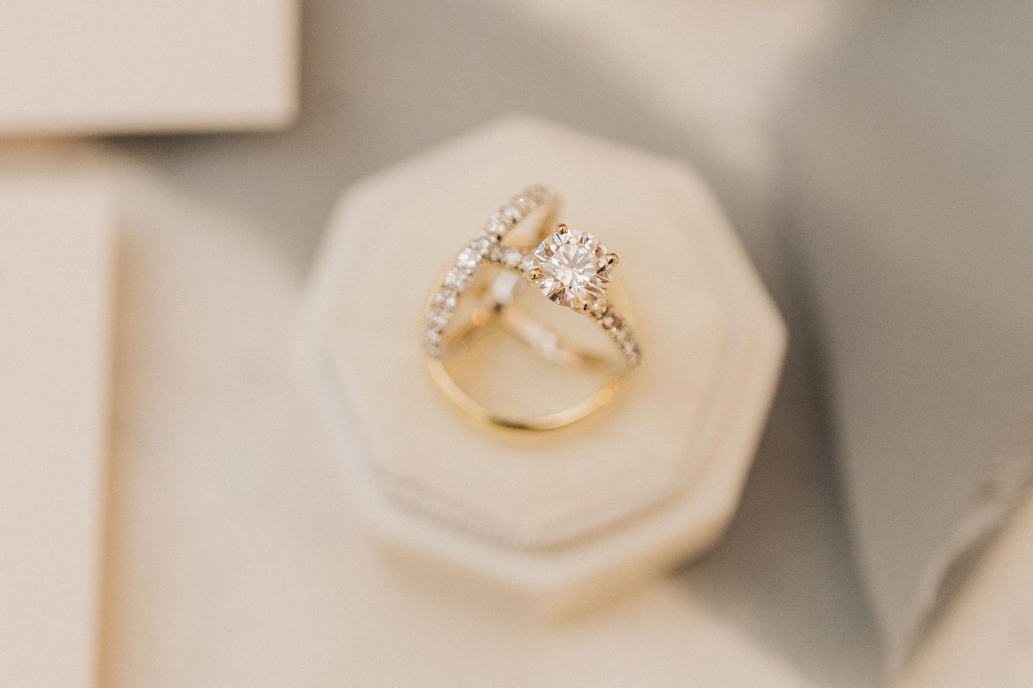 Elegant diamond wedding ring set displayed in a white octagonal jewelry box.