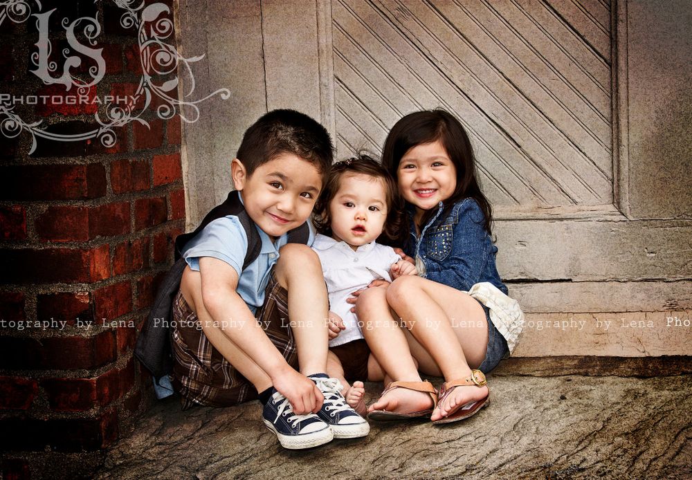 Children sitting together on wooden steps during casual portrait photography session.