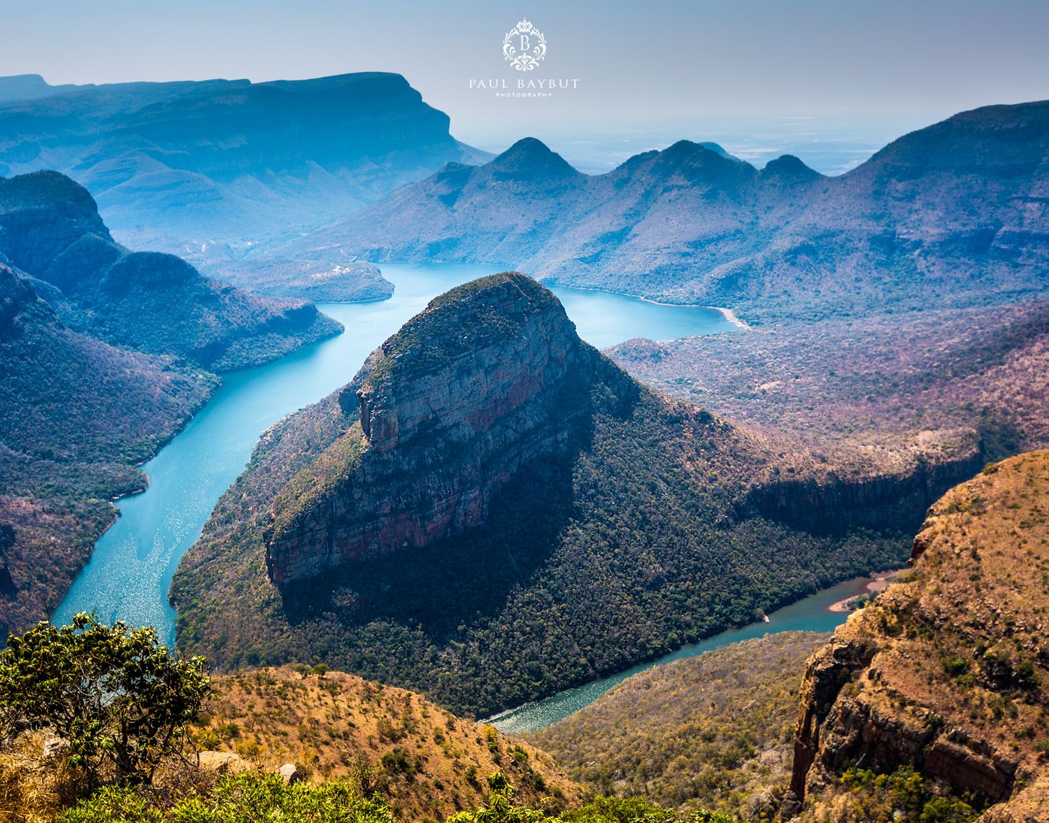 Aerial view of Blyde River Canyon in South Africa with winding river and mountains.