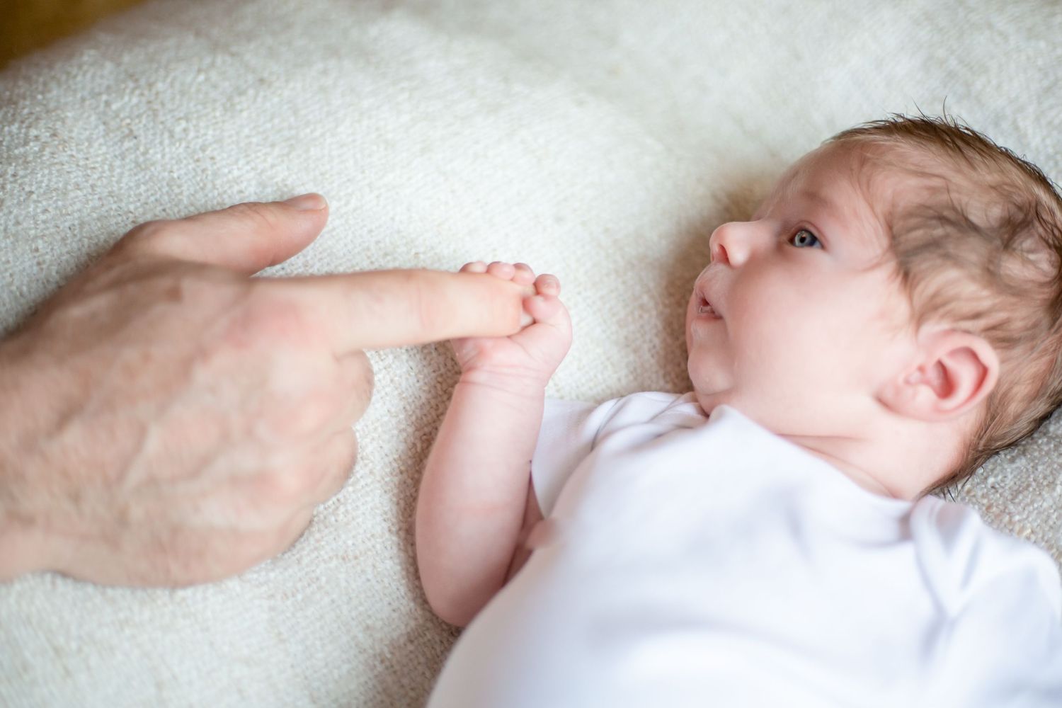 newborn holding fathers finger