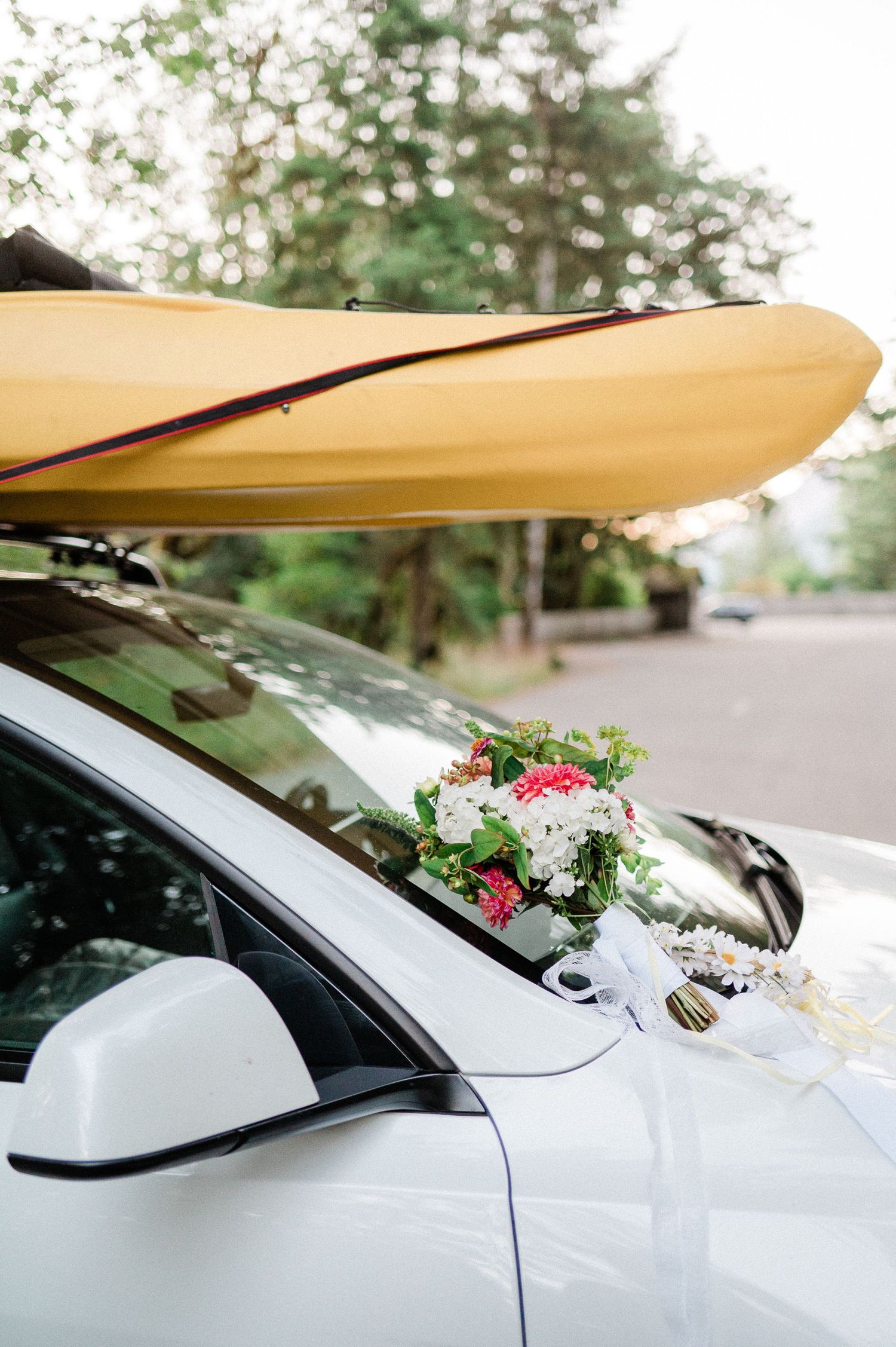 Canoe on car with bridal bouquet. Photo by Pine + Vow