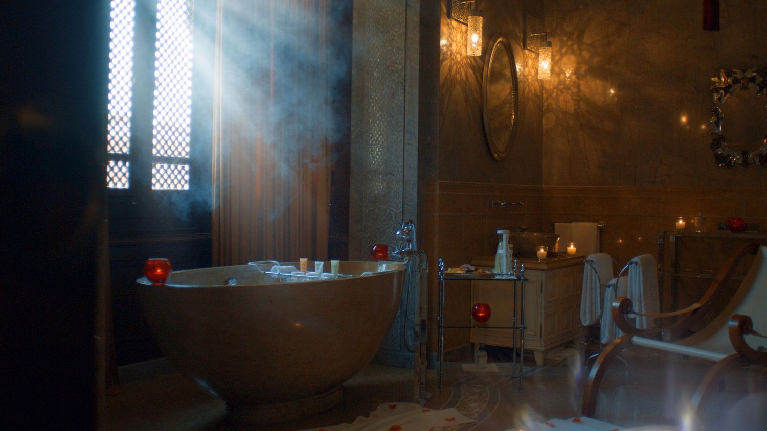 Elegant bathroom interior with ornate bathtub and vintage lighting fixtures.