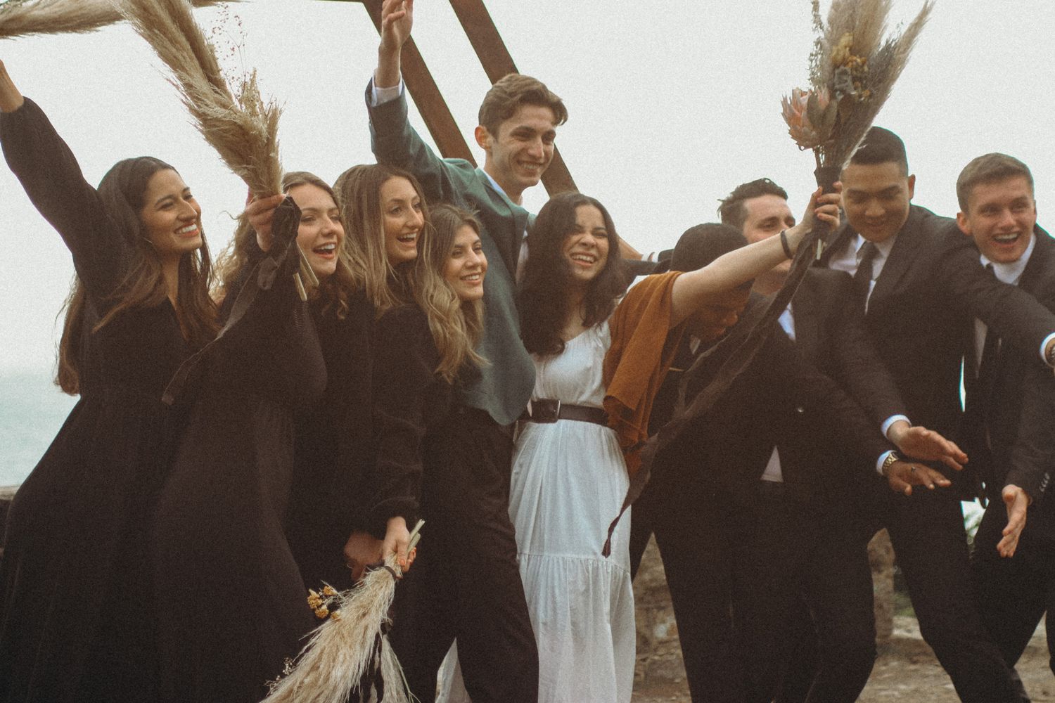 Wedding party celebrating friends and love holding up flowers