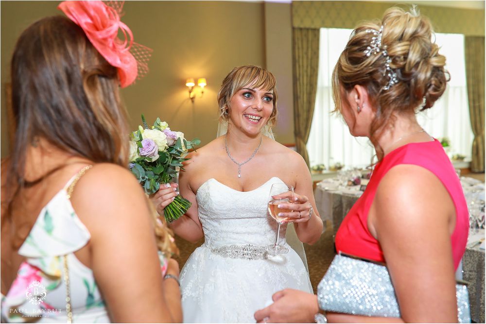 Wedding celebration with guests in colorful attire chatting during reception.