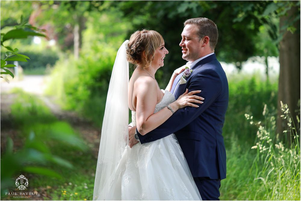 Intimate wedding moment captured in lush garden setting with natural lighting.