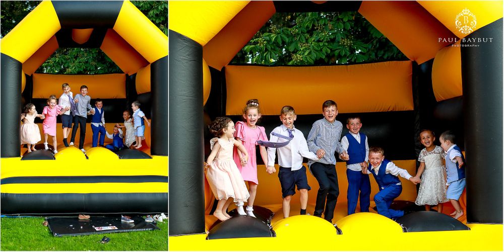 Wedding party having fun jumping and posing in a colorful bouncy castle outdoors.