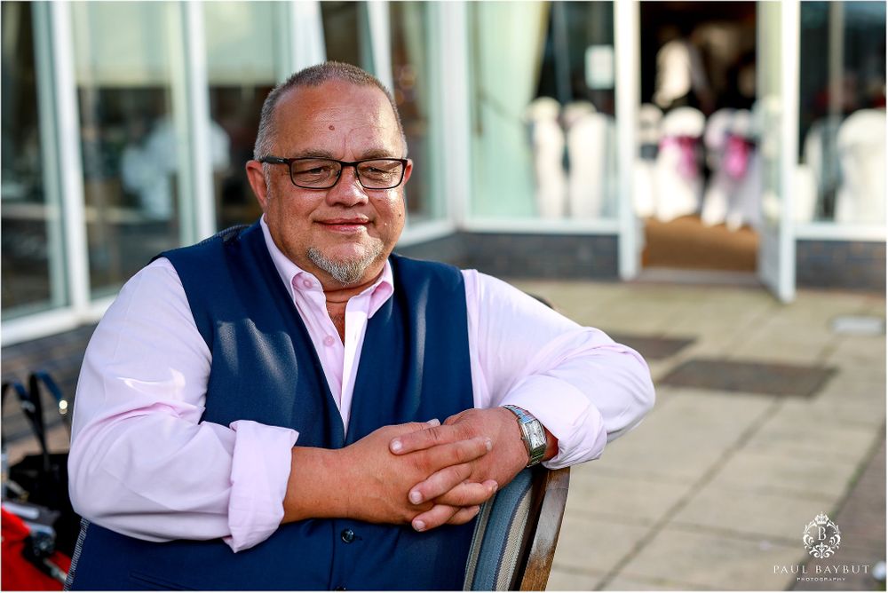 A casual outdoor portrait of a guest in formal attire at a wedding reception.