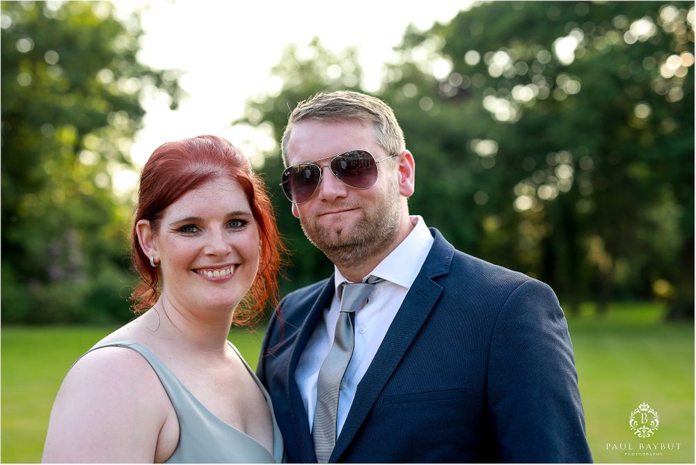 A casual outdoor portrait of a couple at a summer wedding event.