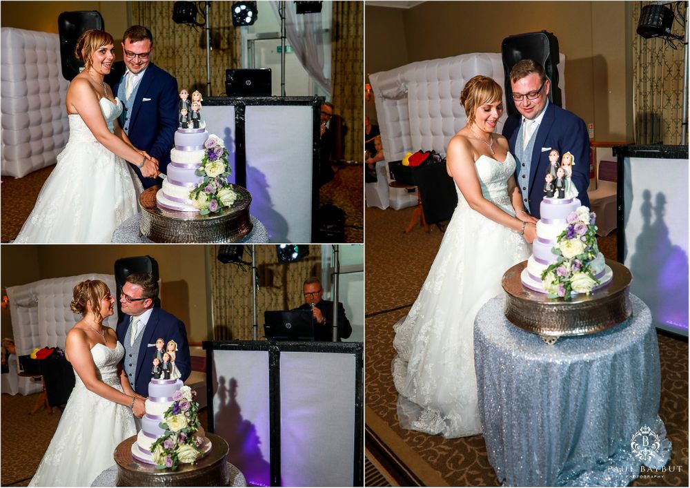 Newlyweds cut their elegant tiered wedding cake at reception.