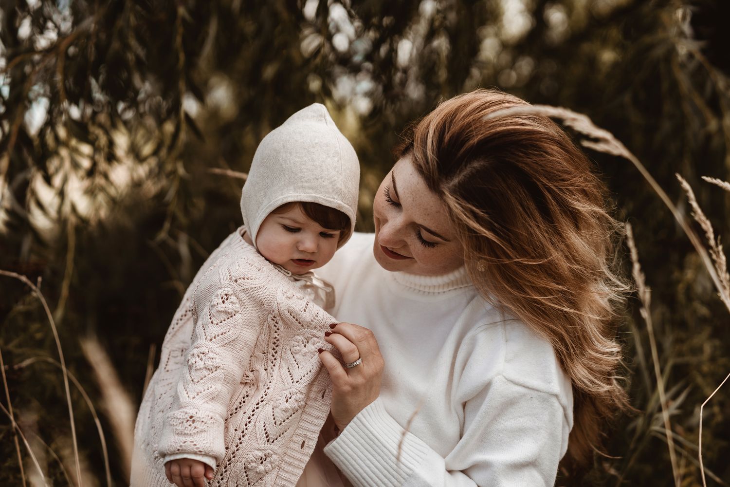 Heartwarming outdoor portrait under willow trees in warm natural lighting.