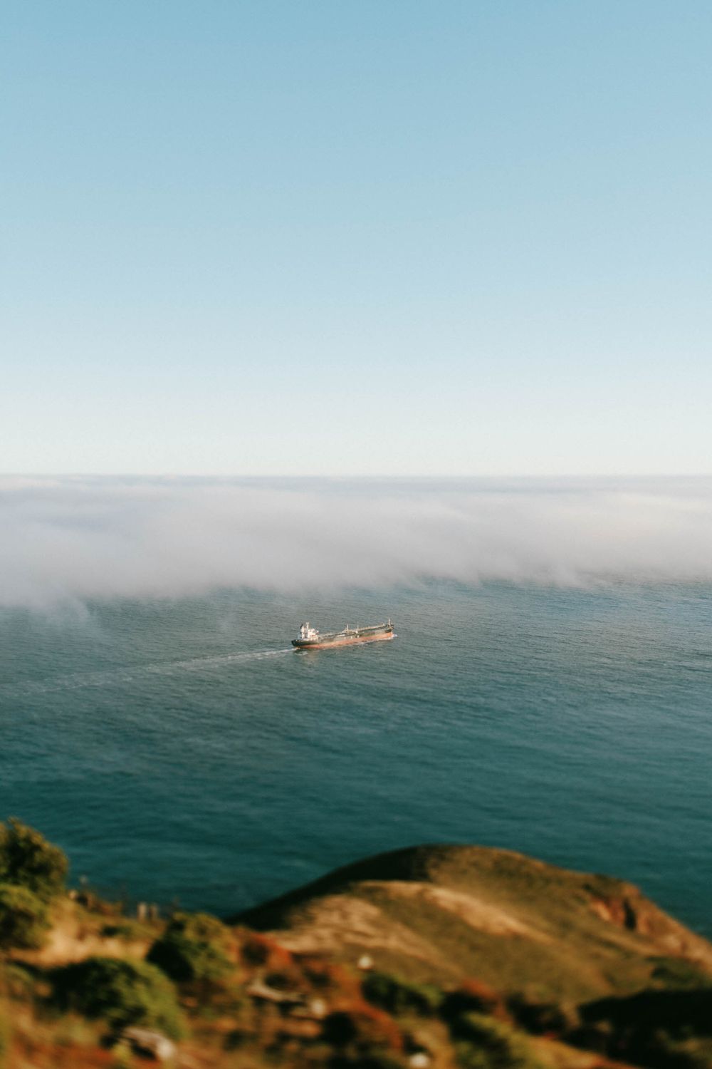 Misty ocean view with small island visible through coastal fog layer.