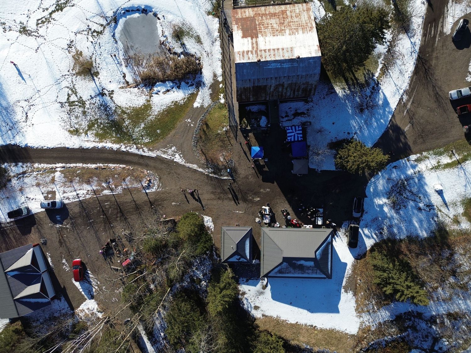 Bird's eye view of winter venue buildings and pathways with scattered gatherings.