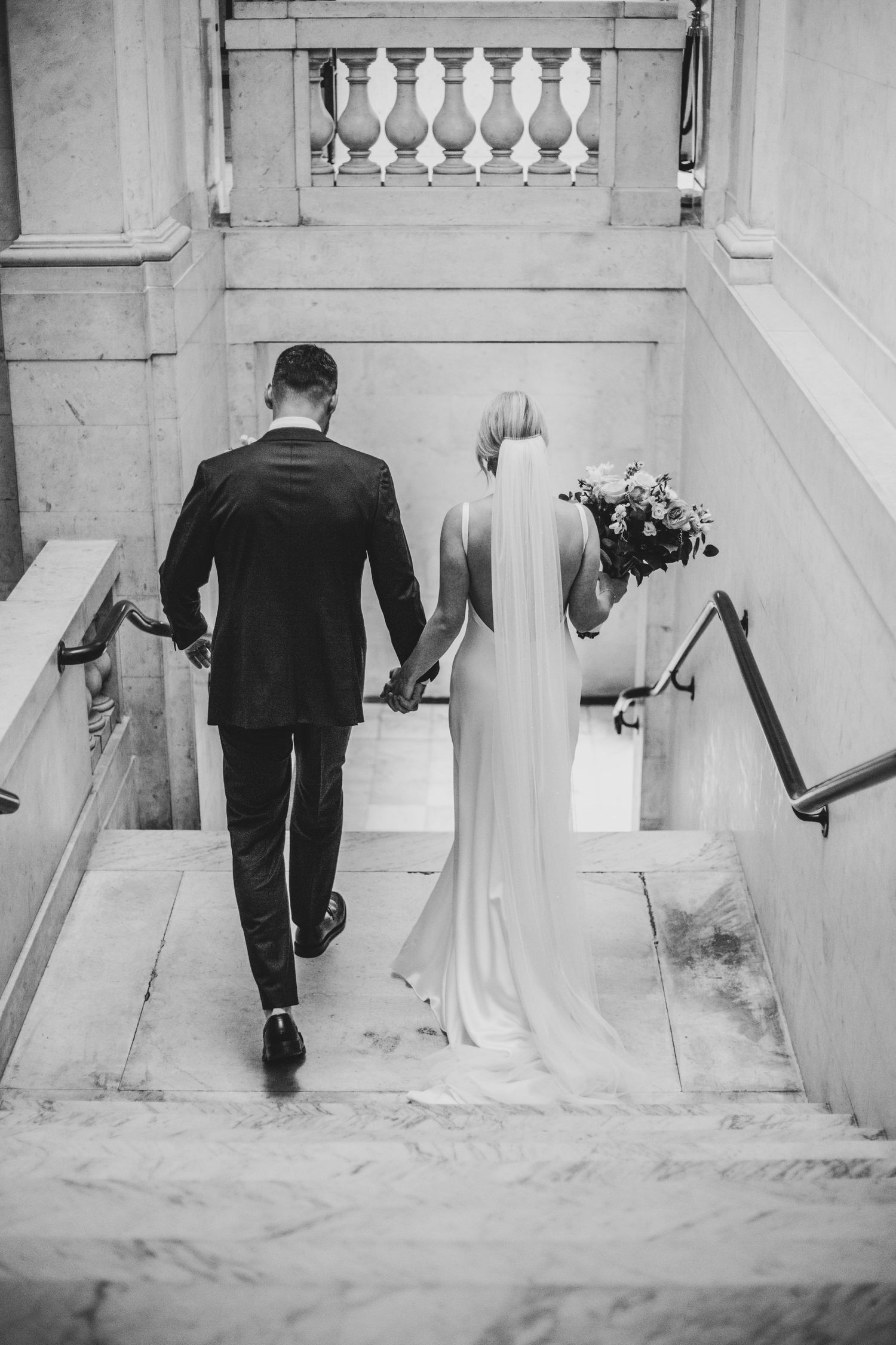 bride and groom walking down stairs at Old Marylebone Town Hall, London by Dominique Lauren photography