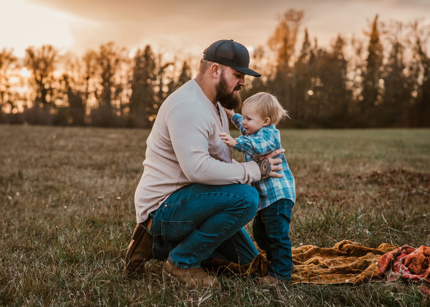 Tender moment shared outdoors during sunset in a field.