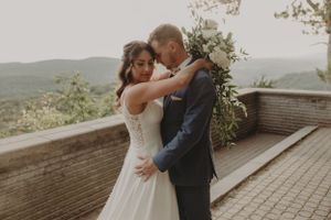 Intimate moment shared on scenic outdoor terrace with mountain backdrop.
