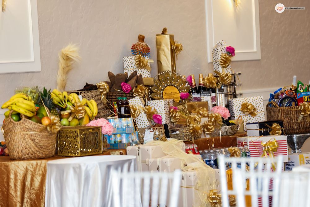 Elaborate Nigerian traditional wedding gift table adorned with gold decorations, fruits, and colorful items.