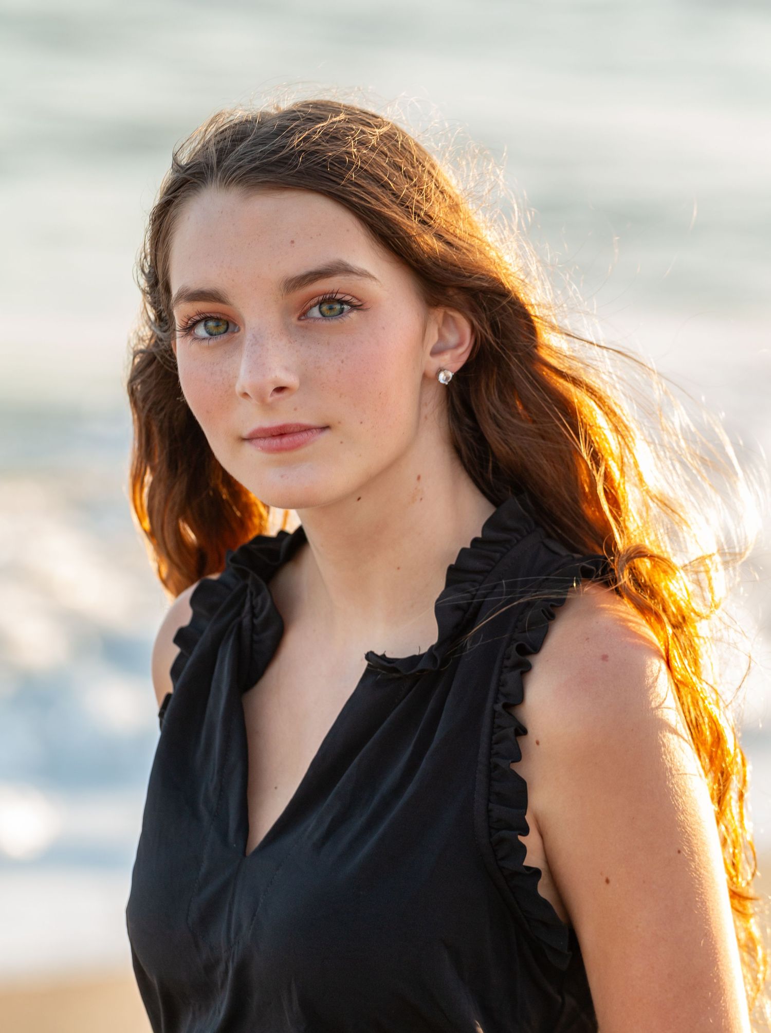 Portrait series in black sleeveless top with soft lighting and natural background.