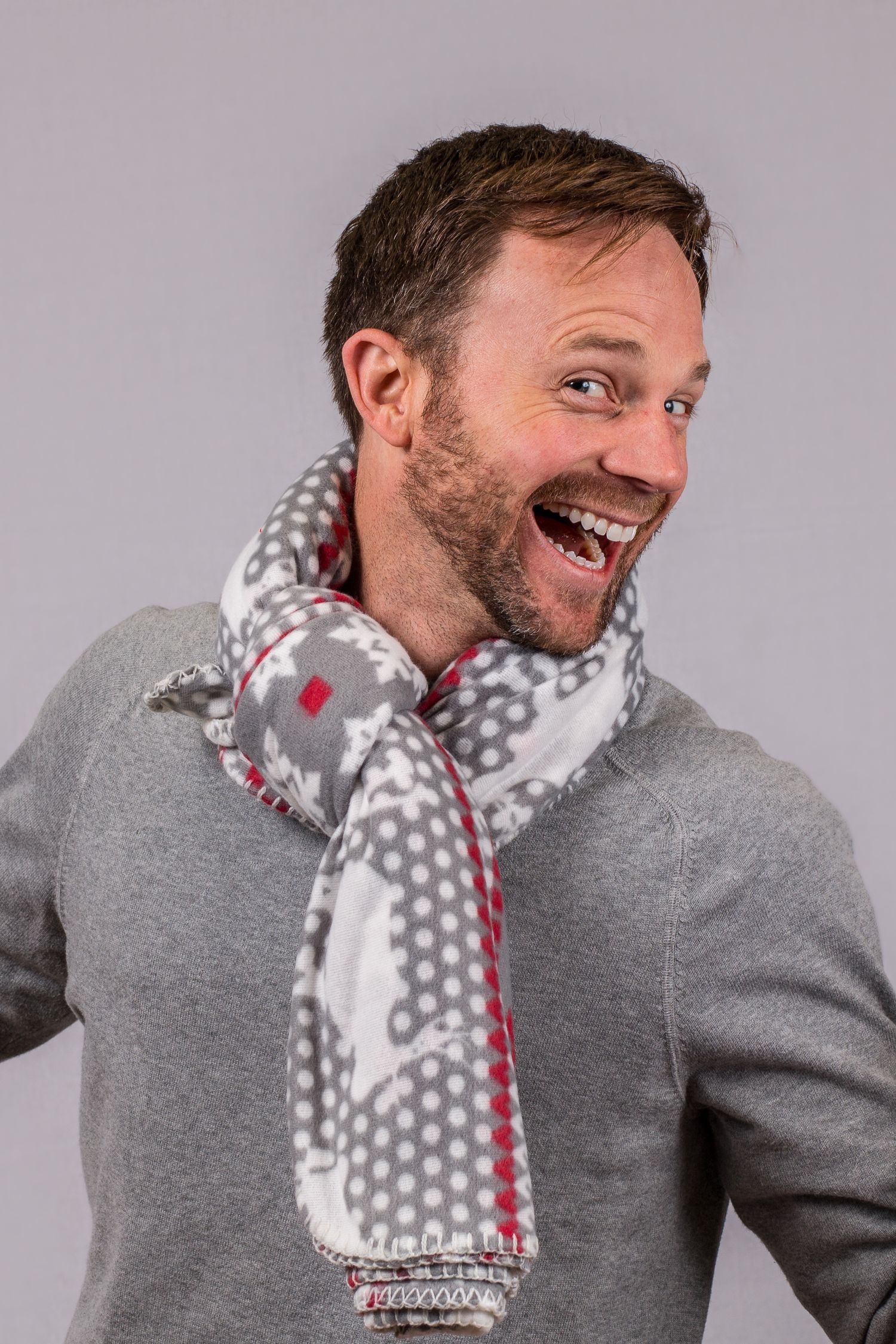 Playful winter portrait series wearing grey sweater and polka dot scarf with animated expressions.
