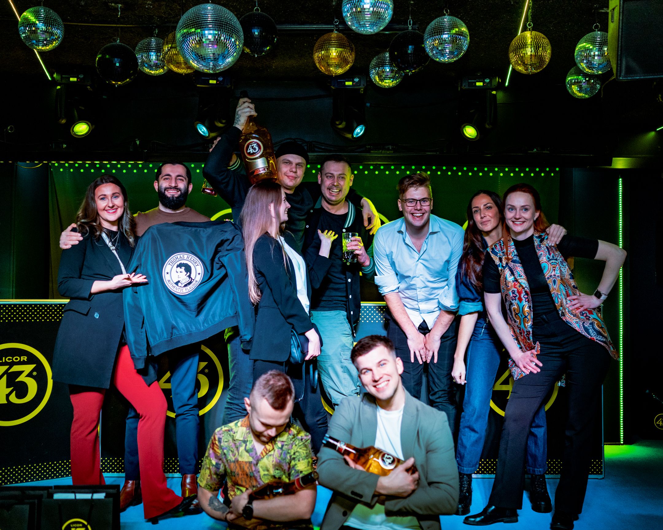 Large group gathered for celebration photo at Licor 43 branded nightclub event.