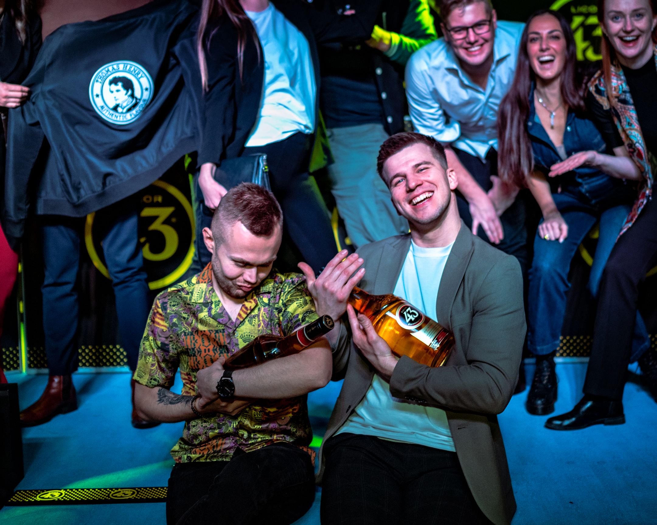 People enjoying themselves at Licor 43 event with bottles and branded merchandise.