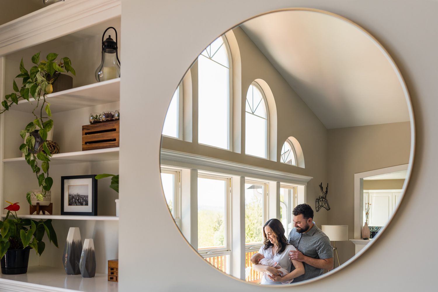 Mirror reflection of family posing with newborn daughter.