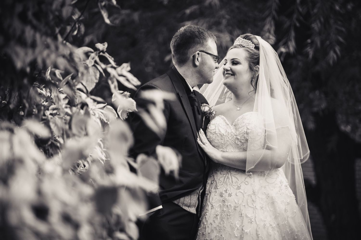 bride and groom looking at each with hand on chest