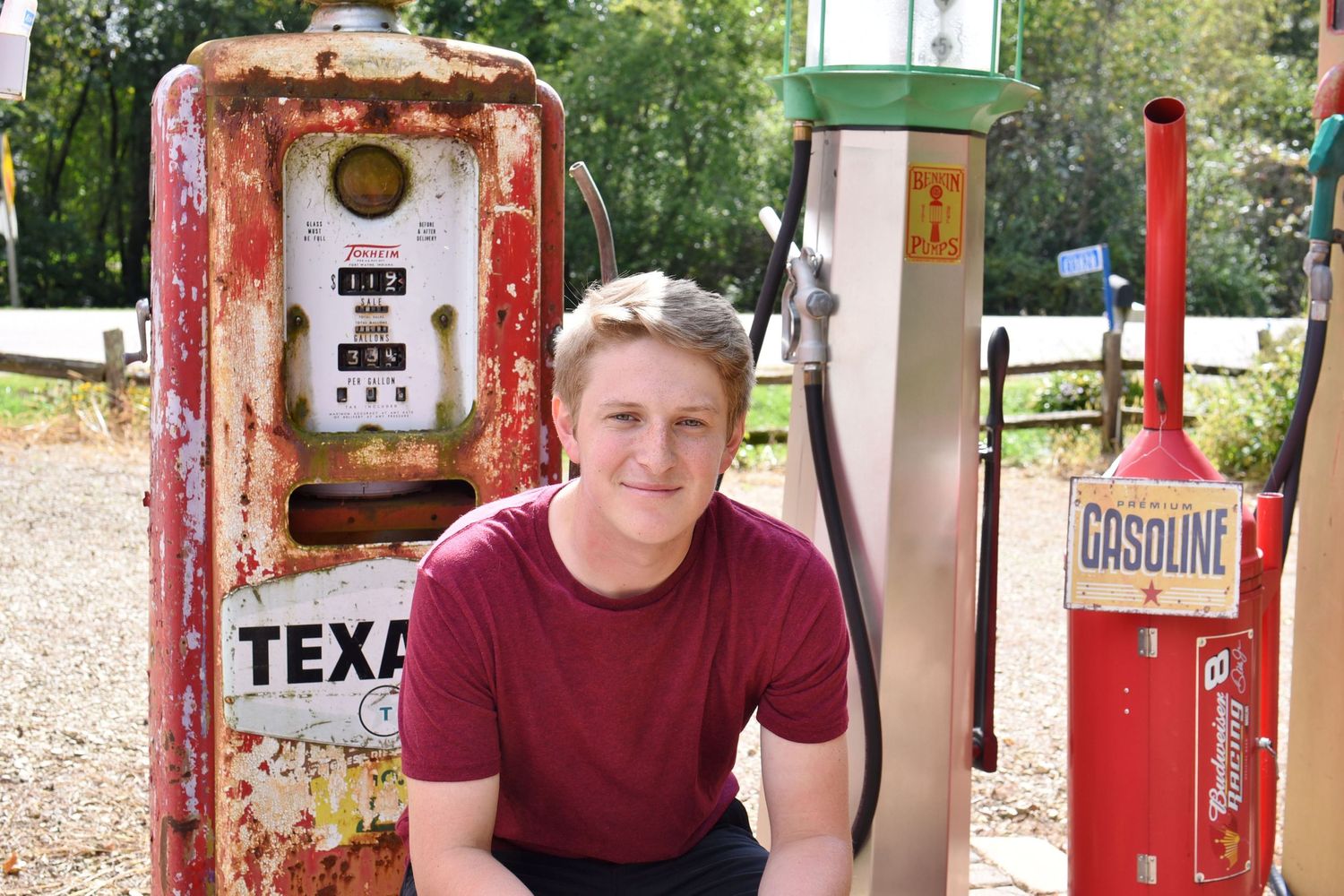 Vintage gas station themed photo session with red retro pumps and rustic aesthetic.