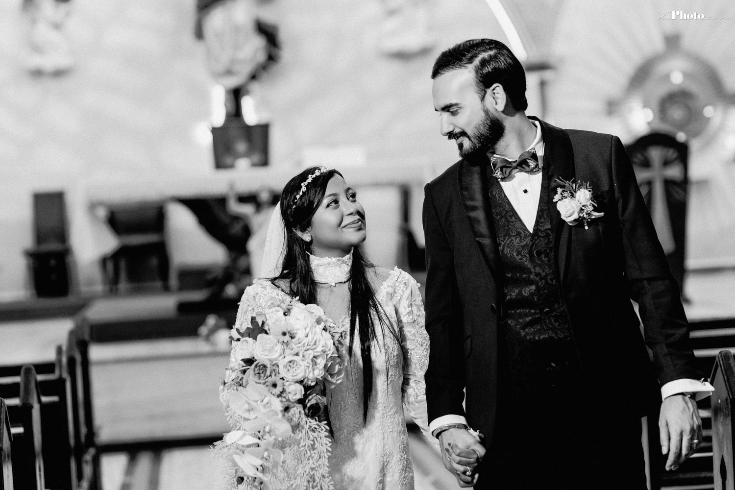 Black and white candid wedding photo captured in church setting.
