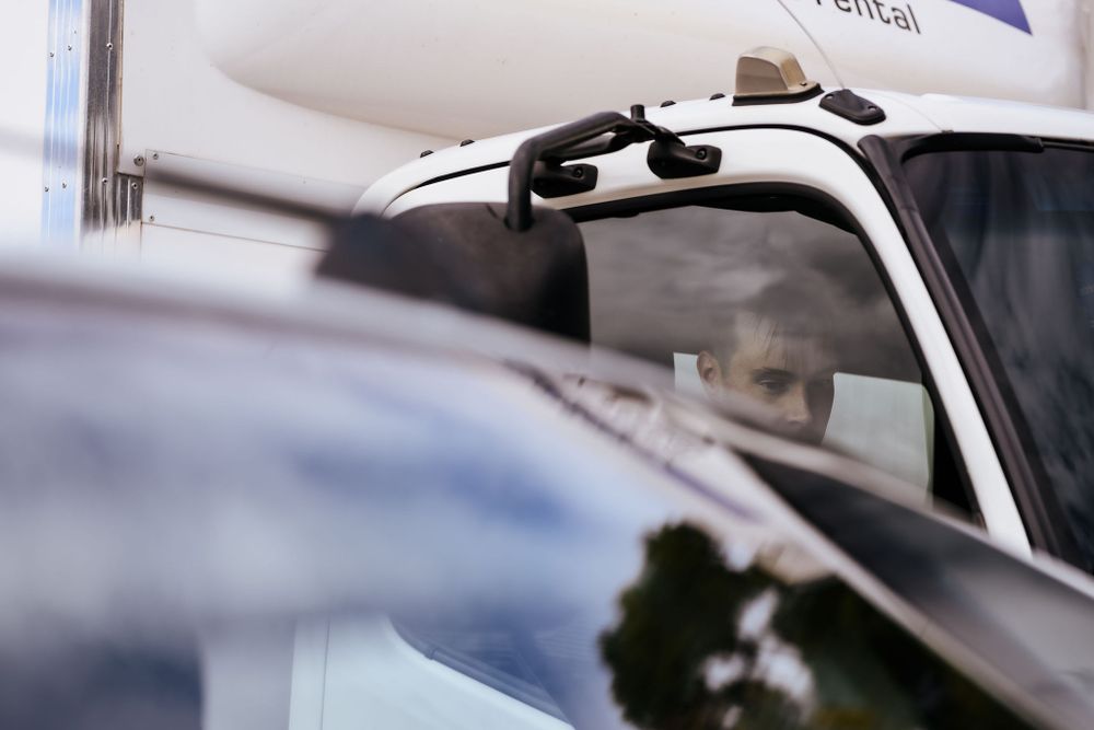 Close-up detail of a white vehicle's roof rack and windows.