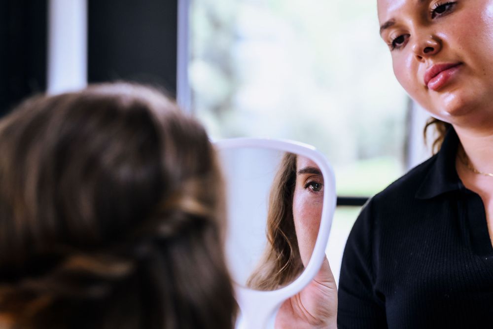 Reflection in a makeup mirror during a beauty preparation session.