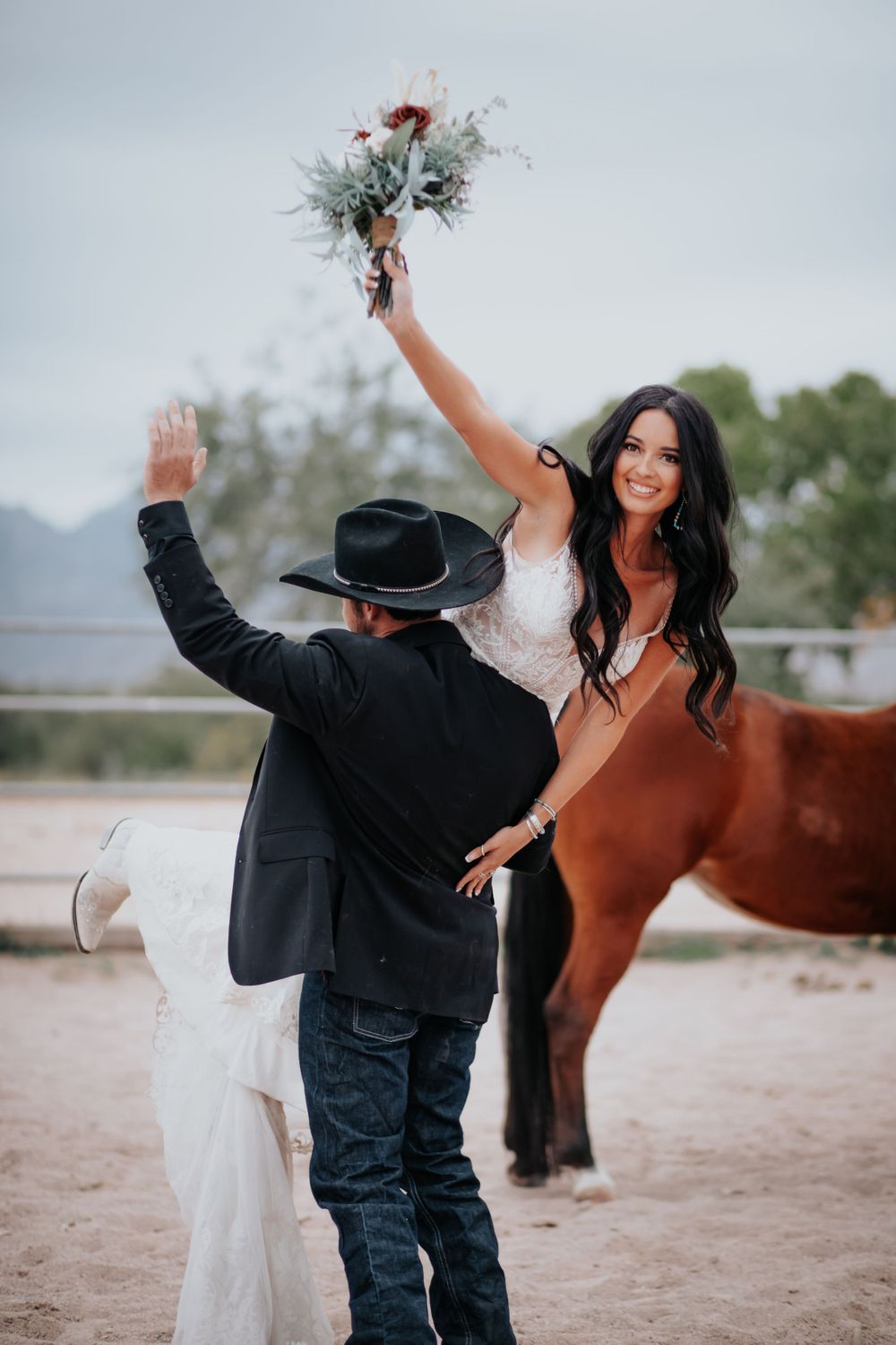 A celebratory moment at a western-themed wedding with a horse in the background.