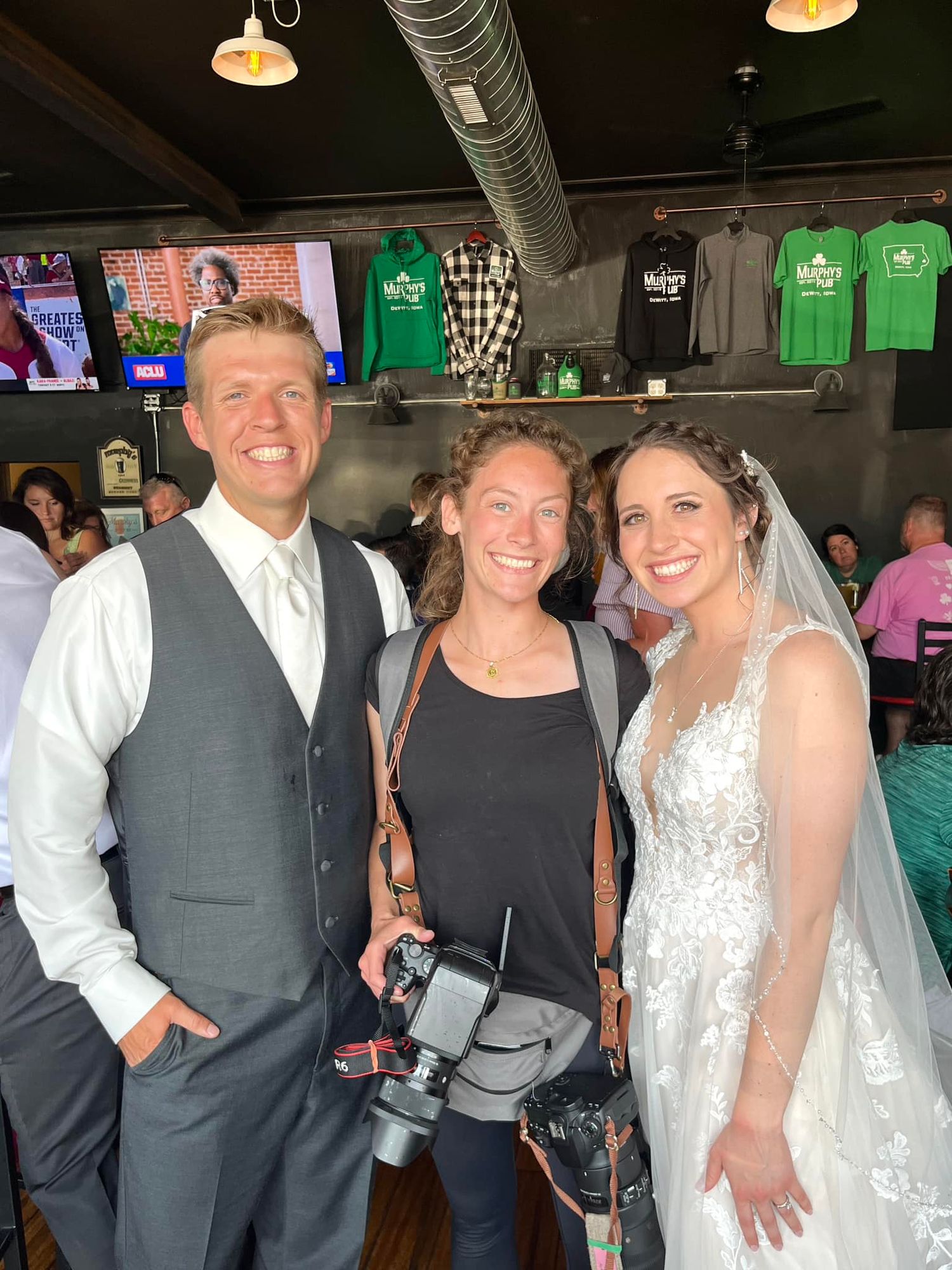 Wisconsin / Iowa wedding photographer stands by bride and groom