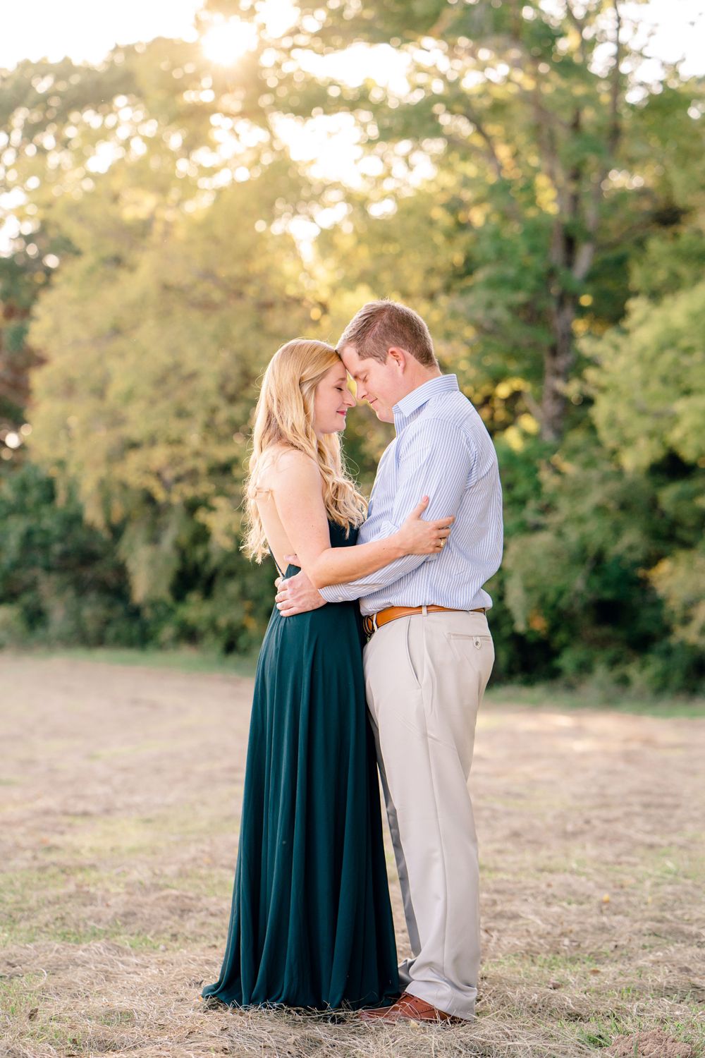 A couple embraces in formal attire during a romantic sunset photoshoot.