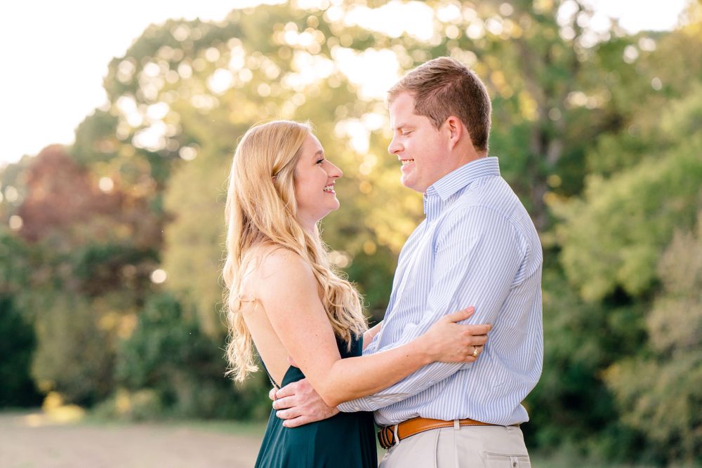 A couple shares a romantic moment in formal wear during golden hour outdoors.