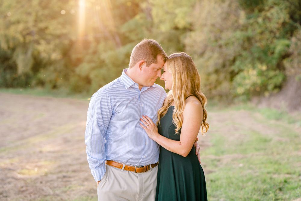 A couple shares an intimate moment at sunset in their formal attire outdoors.