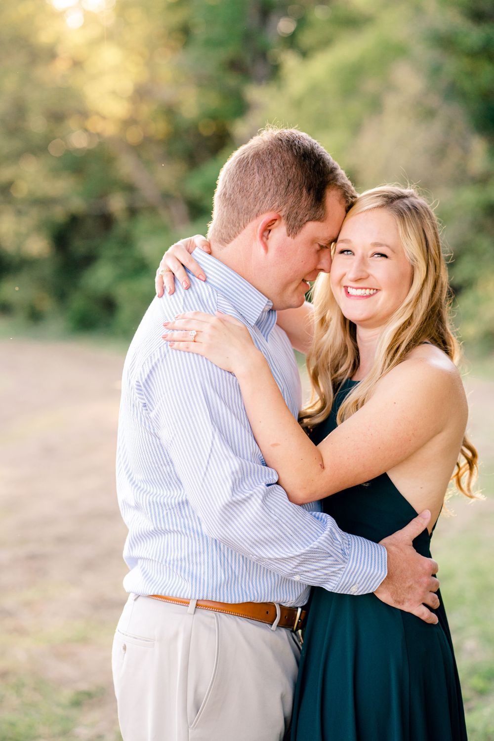 A joyful couple embraces while sharing a laugh during their engagement photo session.