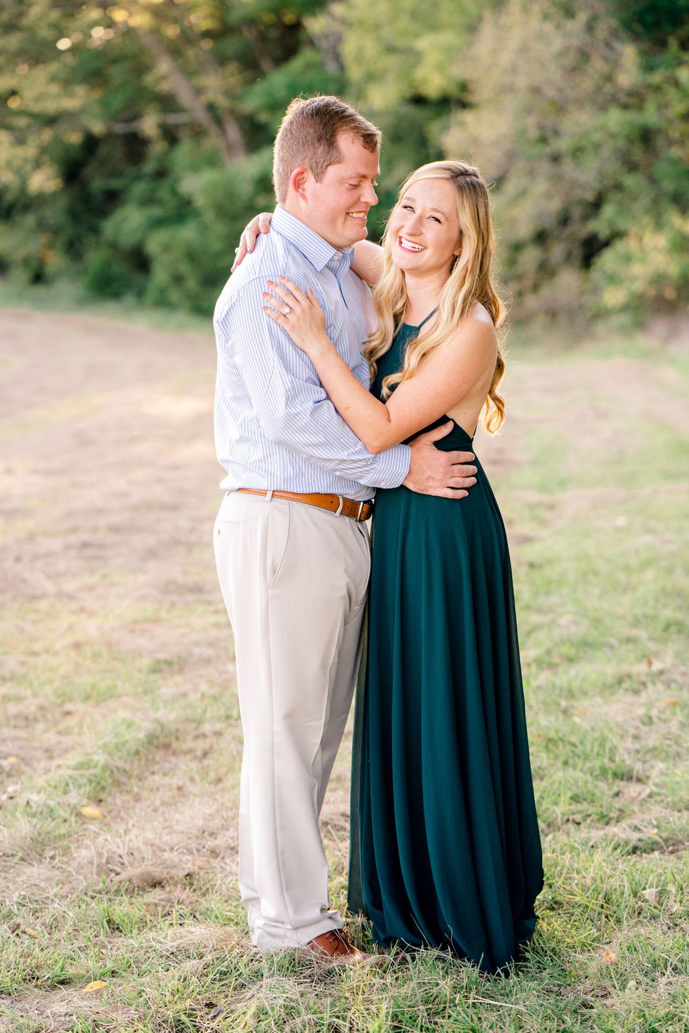 A happy couple in formal wear shares a candid moment during their outdoor photo session.