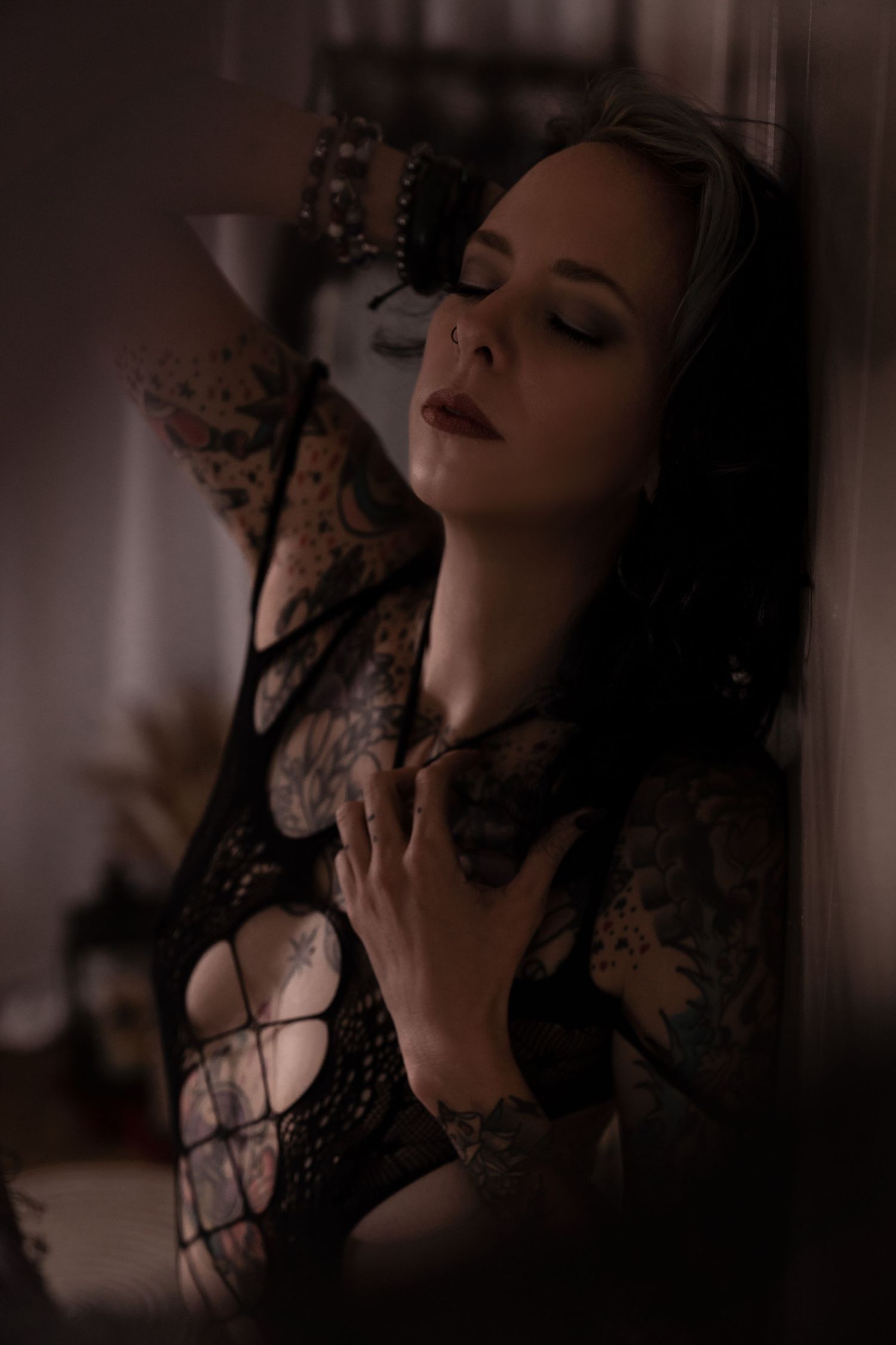 Artistic boudoir portrait with dramatic lighting and lace details.