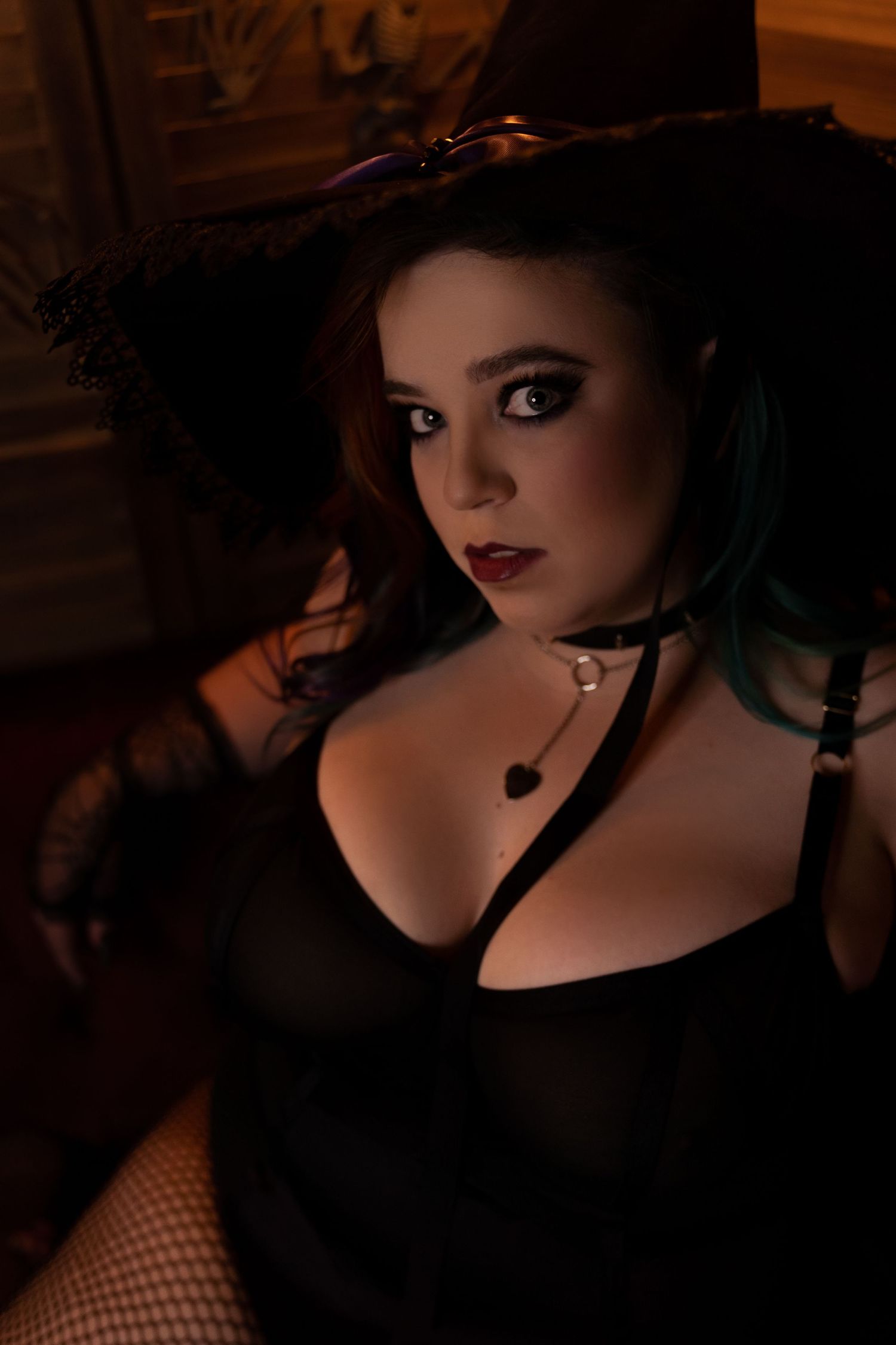 Dark and moody portrait featuring gothic style accessories and dramatic lighting.