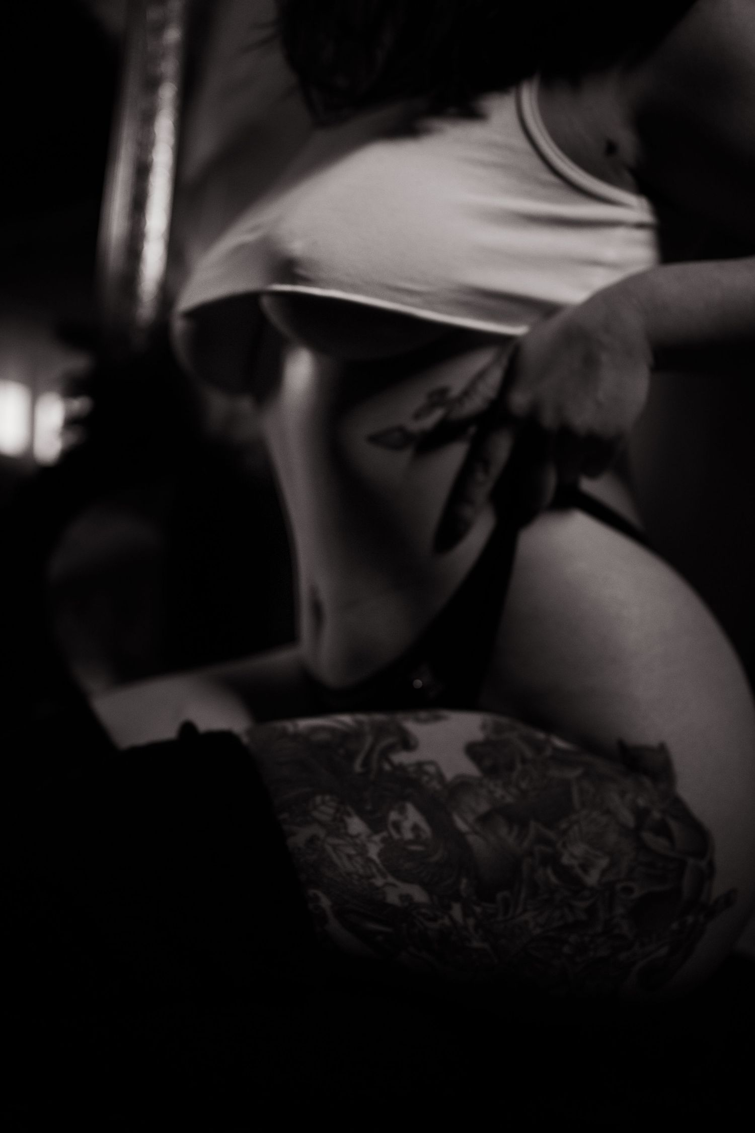Moody black and white boudoir photography with dramatic shadows and textures.