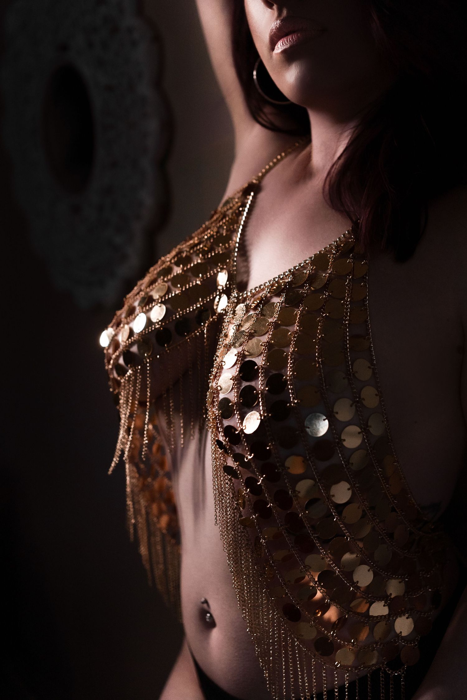 Close-up of shimmering gold sequined garment with dramatic lighting and shadows.