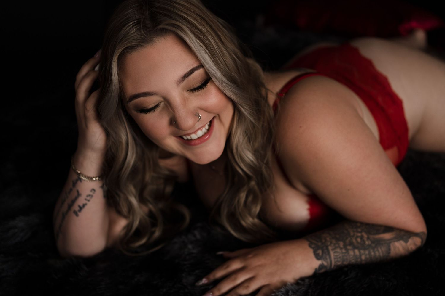 Intimate boudoir photography featuring red lingerie and natural expressions.