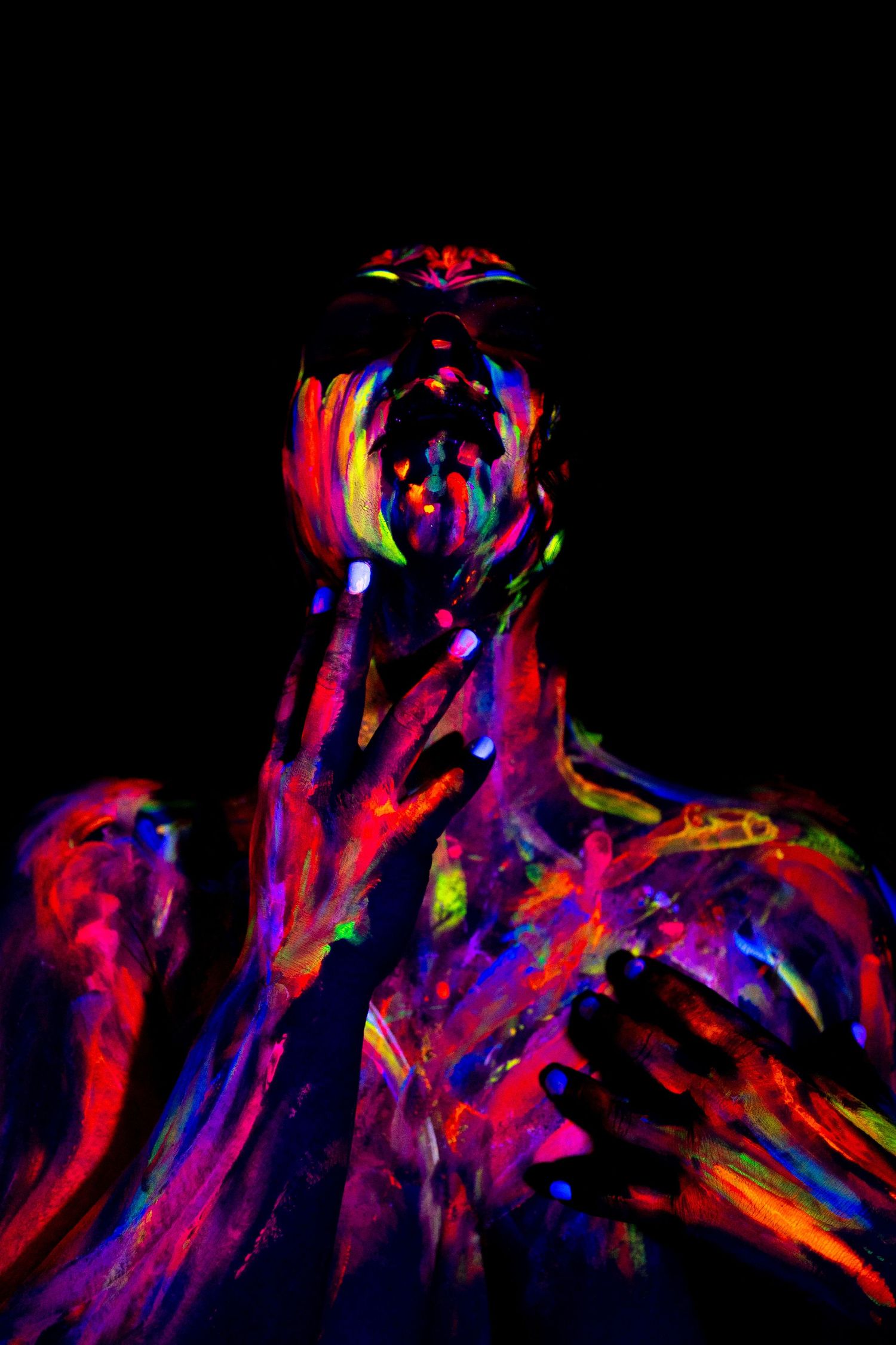 Abstract art photography showing swirling neon colors against black background.